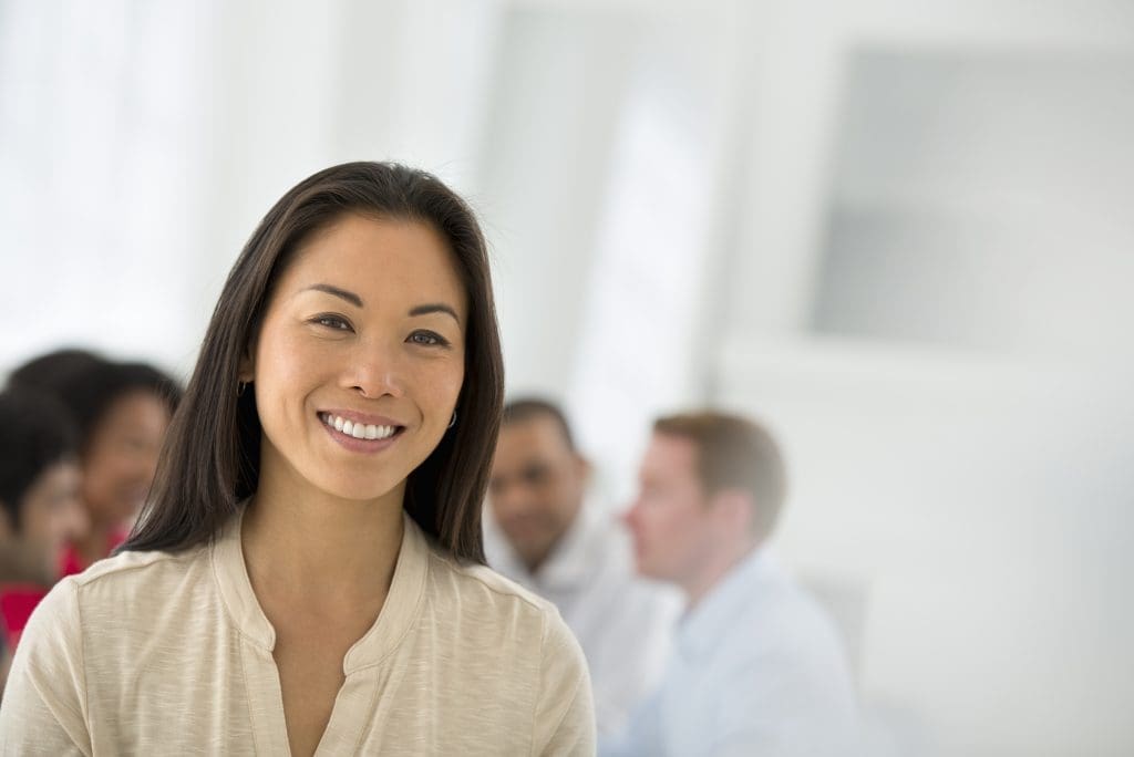 Business Shoot,An office in the city. Business. Team meetings. A group sitting down around a table. One person in the foreground. A confident businesswoman. Leader.